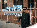 Persoon wandelt met een witte stok in de stad. Slogan: « Alleen op stap gaan heeft een prijs. »