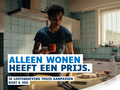Persoon staat in een keuken met een opvouwbare witte stok op tafel. Slogan: « Alleen wonen heeft een prijs. »